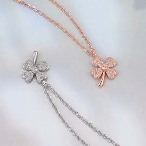 Detail view of silver and rose gold clover necklaces with sparkling pavé zircons