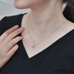 S925 sterling silver crescent moon necklace with pearl and pavé crystals on female model