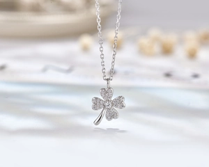 Detailed macro view of S925 sterling silver four-leaf clover pendant with pavé crystals