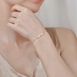 Bracelet papillon élégant en or avec des pierres de zircon sur un poignet féminin