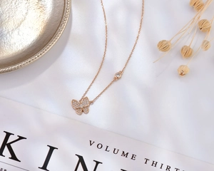 Détail macro du collier papillon en or rose 18K avec sertissage micro-pave de zircon