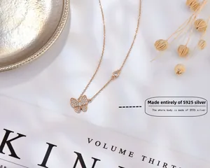 Détail du collier papillon en argent S925 avec zircons et dorure sur un magazine