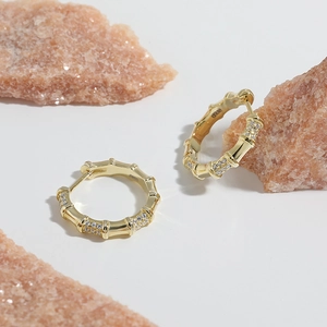 Orecchini a cerchio in argento S925 stile bambù con zirconi su sfondo di cristallo rosa