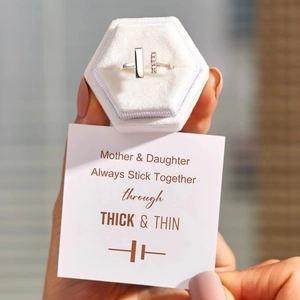 Silver double T ring with diamonds held in hand with a Mother and Daughter gift card