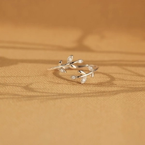 Elegant s925 silver leaf ring with white zircon stones on a warm textured surface