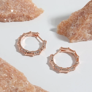 Dettaglio di orecchini a cerchio in argento S925 a forma di bambù con zirconi in oro rosa