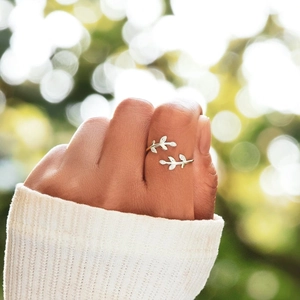 Detail of s925 silver leaf ring with cubic zirconia worn on finger in natural light