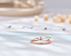 Detail of adjustable rose gold sterling silver chain ring with slide bead and texture