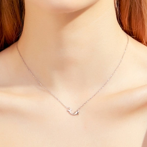 Collier dauphin minimaliste en argent S925 porté sur la clavicule d'un mannequin élégant