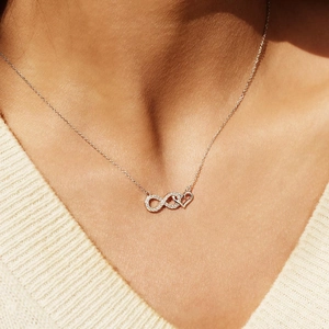 Elegant S925 silver infinity heart necklace with sparkling crystals on a female model