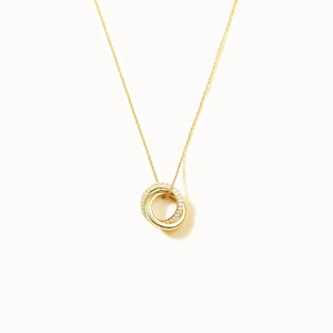 Macro shot of interlocking dual-circle pendant with pavé crystals on a fine gold chain