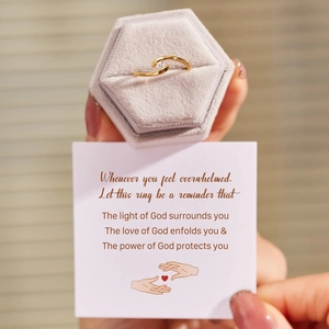 Detail of a gold solitaire ring with intertwined band in a velvet box and gift card