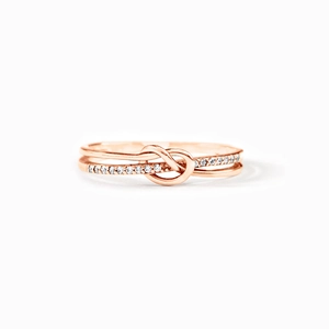 Vue macro d'une bague nœud en or rose sertie de cristaux blancs scintillants