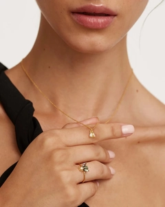 Detail of s925 gold bee pendant necklace and bee ring with green gemstone on model