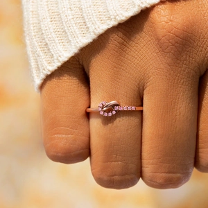 Polished rose gold knot ring for women with pink zircon pavé setting on model finger