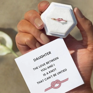 Rose gold knot ring with pink stones in a velvet box with a romantic gift card
