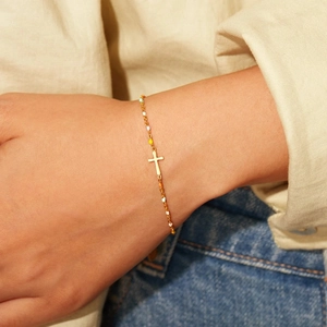 Bracelet croix en argent s925 doré avec perles émaillées colorées porté par une femme