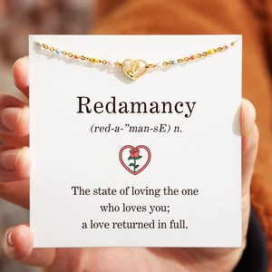 Detail of gold heart necklace with rose pendant on a Redamancy dictionary card