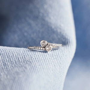 S925 sterling silver ring with double heart-shaped cubic zirconia on denim background