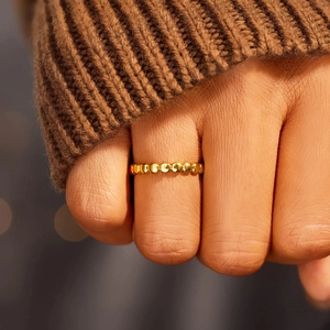 Bague perlée minimaliste en argent S925 doré portée avec un pull en tricot marron