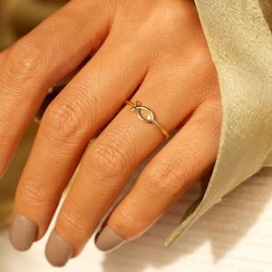 Bague poisson Ichthys élégante en or avec pierre brillante portée sur une main