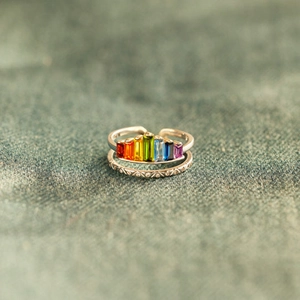 Detail view of double-layered silver ring with rainbow zircon and vintage patterns