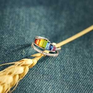 Macro detail of rainbow zircon silver ring set with vintage texture on denim backdrop