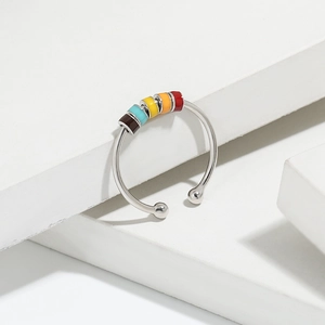 Detail of s925 silver stress relief ring with five colorful rotating beads on white stone