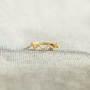 Macro shot of S925 sterling silver golden wavy ring with tiny white diamonds detailing