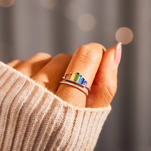 Detail of stacked s925 silver rings with colorful baguette-cut rainbow cubic zirconia