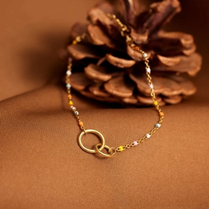 Detail of s925 gold double interlocking rings and colorful enamel beads on silver chain