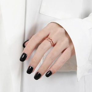 Macro detail of rose gold double zigzag ring with white cubic zirconia on hand