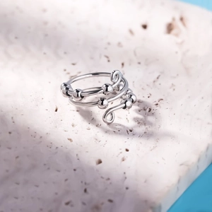 Detail of S925 sterling silver anxiety ring with rotating beads on white stone