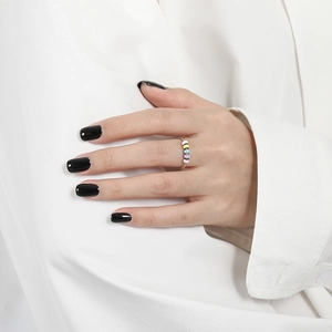 Detail of colorful beads on a spinning S925 sterling silver anti-anxiety ring worn on finger