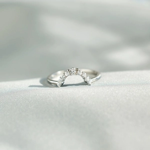 Macro shot of S925 sterling silver arched ring with pavé cubic zirconia on silk