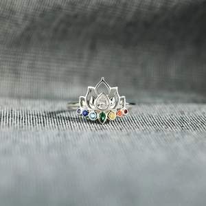 Macro shot of silver lotus ring featuring colorful gradient zircon stones and drop-shaped crystal
