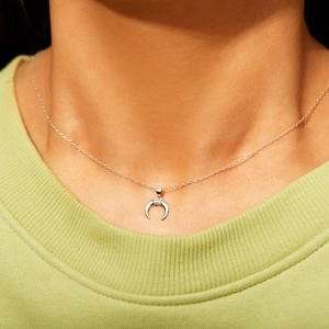 Collier croissant de lune en argent s925 avec zircons porté sur le cou d'un modèle