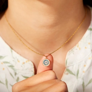 Élégant collier mauvais œil en argent s925 doré porté par une femme sur une chaîne fine