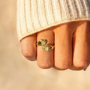 Golden S925 sterling silver hug ring featuring a unique hugging hands design on finger