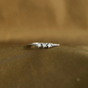 Détail macro de la bague en argent S925 avec trois étoiles en zircon et anneau perlé