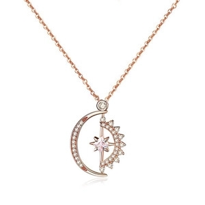 Macro detail of rose gold moon and star pendant with pink stone and zircon inlay