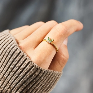 Bague papillon élégante en argent s925 avec zircons verts sur une main de femme