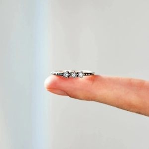 Détail d'une bague en argent s925 avec trois étoiles en zircon et anneau perlé