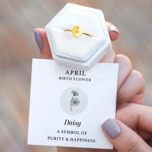 Detailed view of April daisy birth flower ring with golden finish and velvet gift box