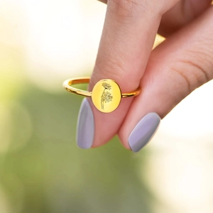 Detailed close-up of a gold daisy engraved S925 silver signet ring on a model hand