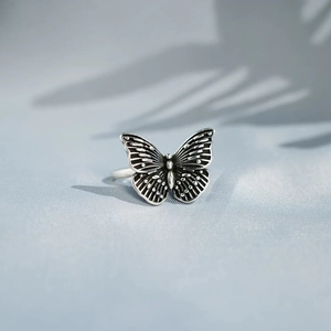 Detailed close-up of s925 silver butterfly ring with vintage black oxidized texture