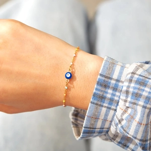Détail d'un bracelet œil protecteur en argent s925 avec perles colorées sur un poignet