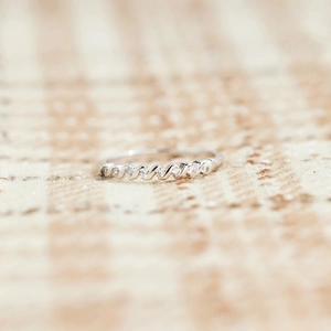 Macro shot of twisted S925 sterling silver ring featuring fine pavé zircon settings