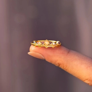 Vue détaillée d'une bague couronne en or avec pierres d'opale sur le bout du doigt