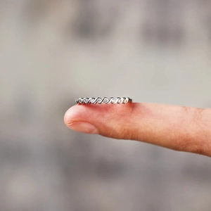Macro detail of twisted S925 sterling silver ring with inlaid sparkling round zircons